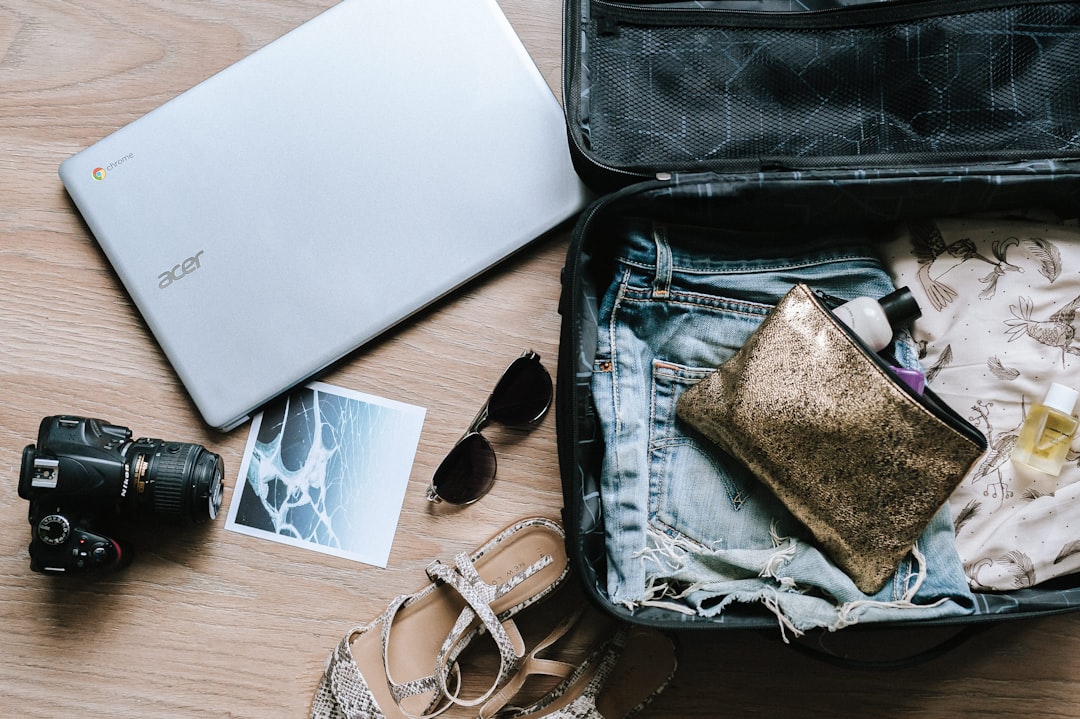 Photo by Anete Lūsiņa black DSLR camera near sunglasses and bag